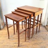 An Edwardian mahogany quartetto set of nesting tables with inlaid chequerboard tops and frieze, on
