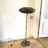 A modern floor lamp, the perforated shade in the form of a flattened Chinese lantern, with