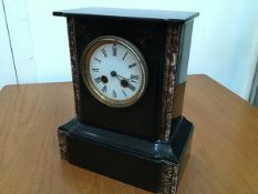A 19thc black slate and marble mounted mantel clock with enamelled dial and twin key apertures, with