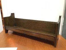 A 1930s oak book trough of V shaped form, raised on shaped end supports (25cm x 64cm x 18cm)