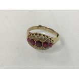 An 18ct gold ruby and diamond ring, early 20thc. with five graduated rubies between twin lines of