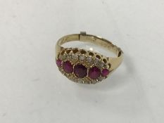 An 18ct gold ruby and diamond ring, early 20thc. with five graduated rubies between twin lines of