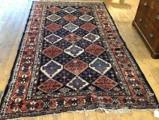 A Caucasian rug, the centre panel with lattice, diamond and flowerhead alternating design, some