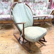 An Ercol dark stained beech spindle back open arm rocking chair, with squab cushion to back and