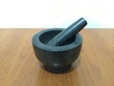 A granite mortar and pestle (mortar: h.10cm x d.15cm)