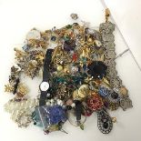 A large assortment of costume jewellery including paste and glass badges, an abalone shell