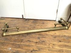 A brass extending fender with raised turned galleries, with ball finials, stamped B.H & R.B. to base