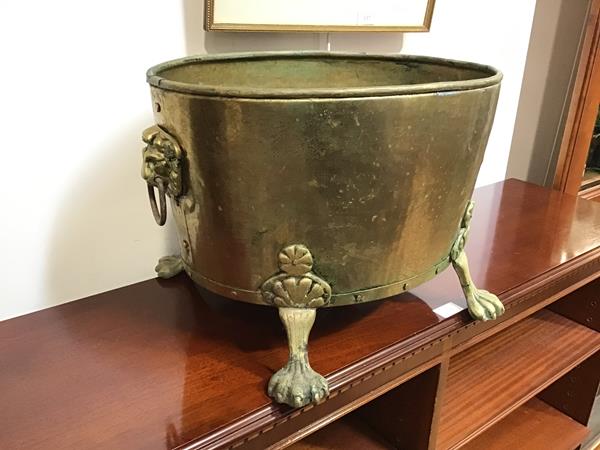 An oval brass jardiniere, with lion mask handles to sides, on four lion paw feet (30cm x 46cm x