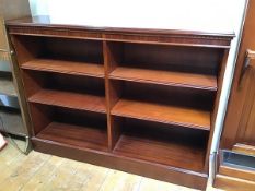 A modern mahogany open bookshelf fitted three shelves with central vertical divider, on plinth