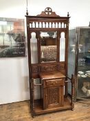 A reproduction Victorian hallstand with bevelled mirror above a single drawer above a cupboard
