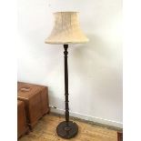 A 1920s standard lamp with turned body on circular reeded base, on bun feet, complete with shade (