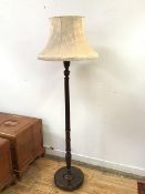 A 1920s standard lamp with turned body on circular reeded base, on bun feet, complete with shade (