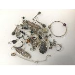 An assortment of silver and costume jewellery including silver feather earrings, silver button