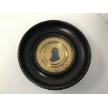 A 19thc. gilt metal Commemorative plaque of Admiral Lord Nelson within a dished ebonised circular
