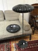 A modern floor lamp with perforated shade in the form of a flattened Chinese lantern, with