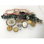 An assortment of costume jewellery including a malachite bead necklace, a coral necklace, a WWI