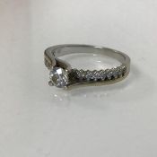 An 18ct gold ring with a single diamond in claw setting, flanked by single rows of diamond points (