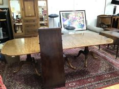 A reproduction mahogany triple pedestal dining table, with crossbanded edge, each pedestal with a