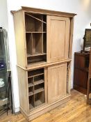 A Victorian stripped pine two section cabinet, each with a pair of sliding doors and fitted interior