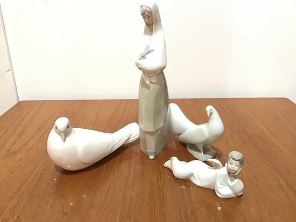 A Spanish Nao porcelain figure of a Recumbent Cherub, a pair of Nao porcelain Doves and a Nao
