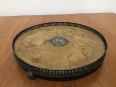 An Edwardian circular oak tray with Epns pierced border, raised on bun feet (4cm x d.25cm)