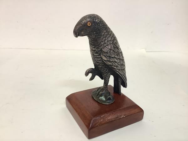 A 19th century white-metal model of a parrot, modelled with one claw upraised and fitted with