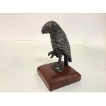 A 19th century white-metal model of a parrot, modelled with one claw upraised and fitted with