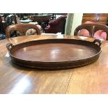 A George III mahogany, brass-mounted and boxwood strung tray, of oval form with loop handles, the