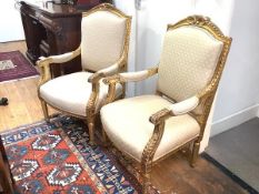 A pair of 19th century giltwood armchairs, in the French taste, each cresting rail with beaded and
