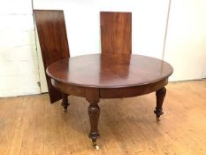 A 19th century mahogany extending dining table, the oval top enclosing two additional leaves, raised