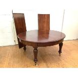 A 19th century mahogany extending dining table, the oval top enclosing two additional leaves, raised