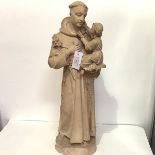 A plaster figure of St. Anthony of Padua, probably c. 1900, modelled with lilies and holding the