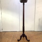 An Edwardian mahogany coat stand of Georgian inspiration, the rotating top with foliate border