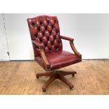 A modern buttoned leather desk chair, the padded back, arms and seat with close-nailed detail,