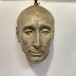 A 19th century plaster mask of a man, his open eyes looking upward, with suspension hook. 27.5cm