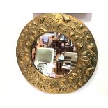 A Scottish Arts & Crafts brass wall mirror, the circular plate within a frame repousse with Celtic