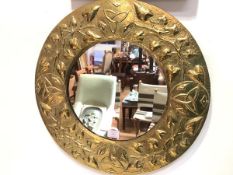 A Scottish Arts & Crafts brass wall mirror, the circular plate within a frame repousse with Celtic