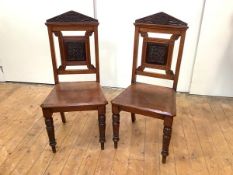 A pair of late Victorian hall chairs, c. 1890, each with pointed pediment with chip-carved