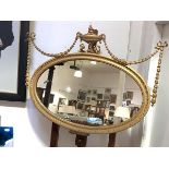 An Edwardian giltwood and gesso wall mirror, the oval plate within a carved egg-and-dart frame