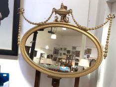 An Edwardian giltwood and gesso wall mirror, the oval plate within a carved egg-and-dart frame