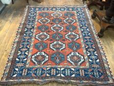 An Afghan Kabul rug of Caucasian design, the brick coloured field with blue-framed ivory and pale