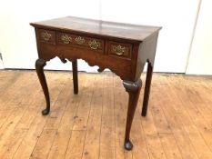 A mid-18th century oak lowboy, the rectangular moulded top above three frieze drawers and a shaped