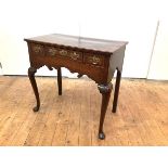 A mid-18th century oak lowboy, the rectangular moulded top above three frieze drawers and a shaped