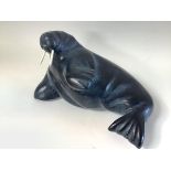 An Inuit carved soapstone model of a walrus, modelled in recumbent pose, bearing paper label "...