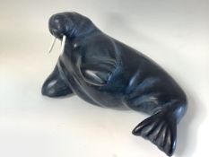 An Inuit carved soapstone model of a walrus, modelled in recumbent pose, bearing paper label "...