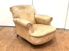 A Victorian easy armchair, upholstered in a gold floral fabric, raised on turned front legs, one