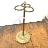 An Edwardian brass stick stand, with urn finial and three hoop divisions, on a turned column and