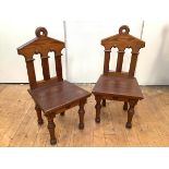 A pair of late 19th century pitch pine hall chairs, the rectangular back of anchor form with loop