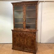 A fine and unusual William IV figured walnut cabinet bookcase, the projecting cornice above a pair