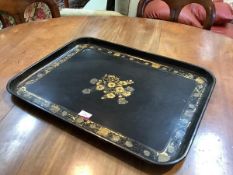 A late 19th century black japanned toleware galleried tray, rectangular, centred by a lacquered gilt